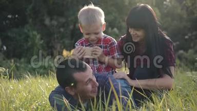 家庭幸福。 绿茵场上的家庭玩家庭游戏.. 在公园里，乐趣是家庭的幸福和休闲。 幸福家庭